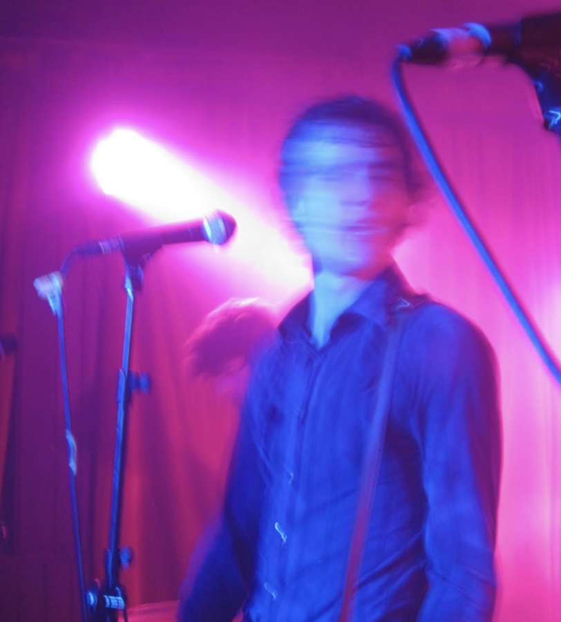 blurred lead singer of band infront of microphone